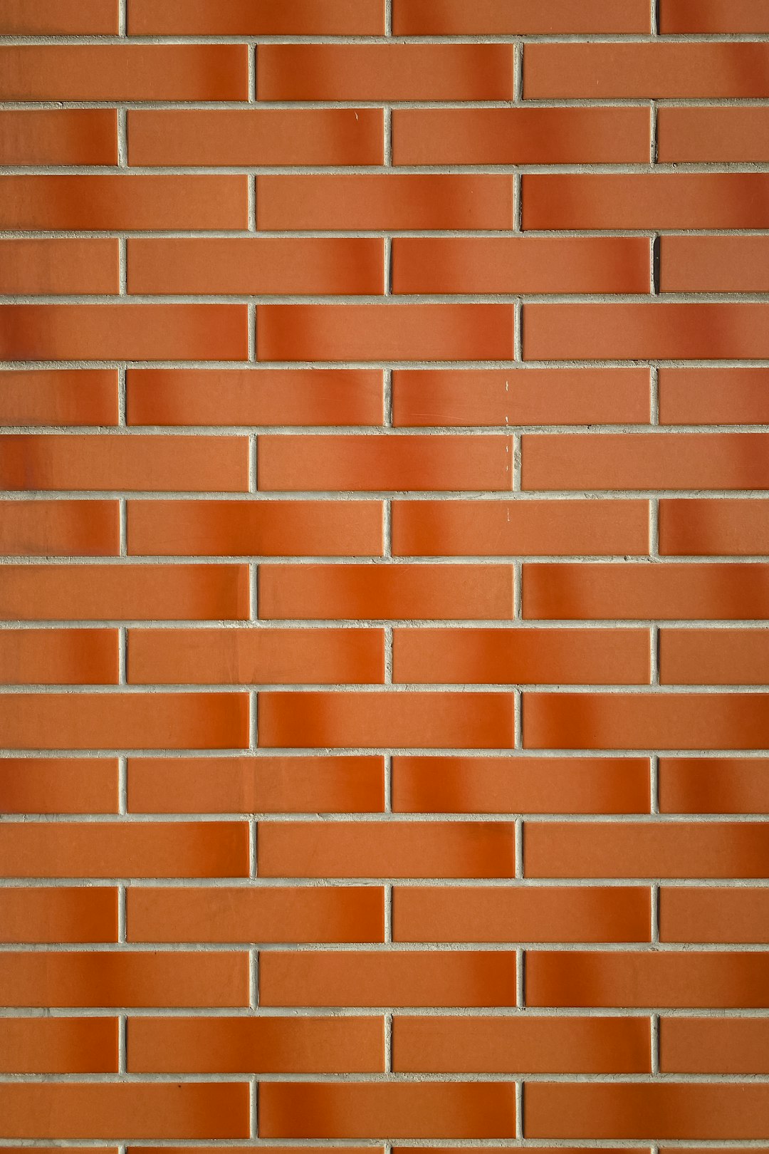 A red brick wall with perfect, uniform bricks arranged in straight lines. The background is solid and flat without any shadows or lighting effects. This design should be minimalist and clean, focusing on the texture of the brick material. Use soft lighting to highlight each individual tile’s detail. High resolution. –ar 85:128