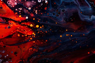 A closeup of swirling red and blue acrylic paint, with bubbles forming in the liquid. The background is dark and moody, adding to the mysterious atmosphere. --ar 128:85