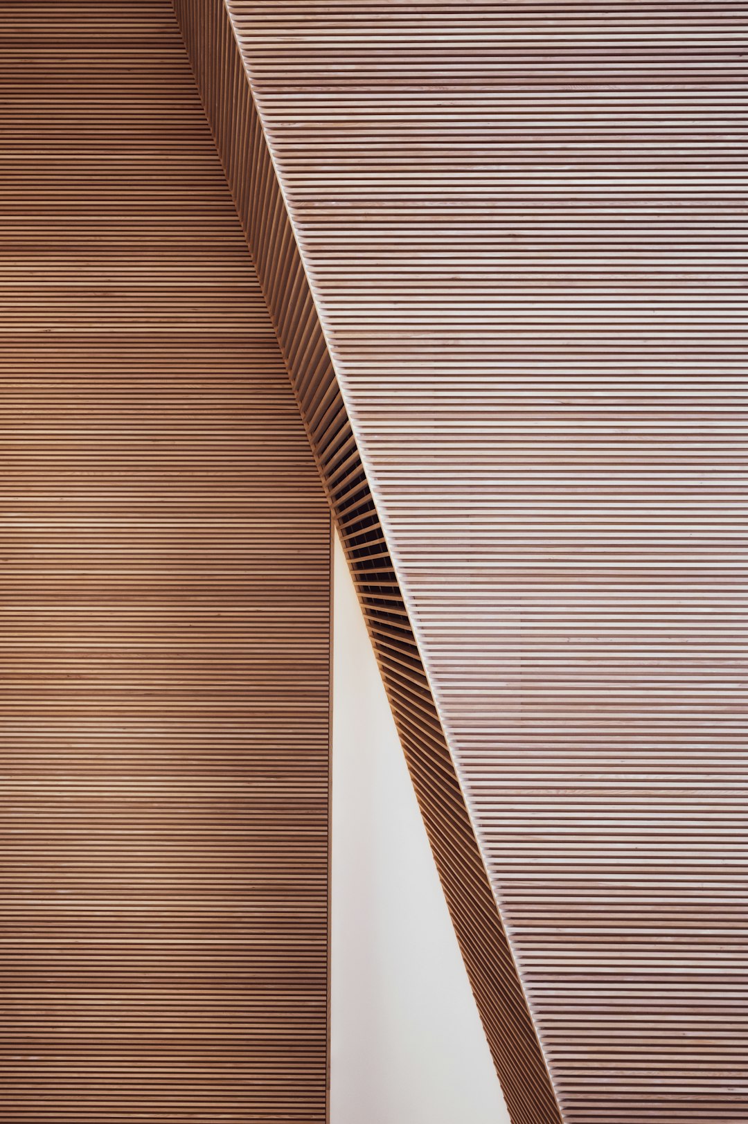 A close-up photo of the corner detail on an interior wall made from light brown wood slats in a modern, minimalist architectural style reminiscent of architectural photography featured in Architectural Digest. –ar 85:128