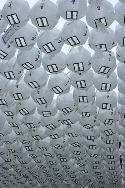 In the center of an outdoor square, white lanterns with black numbers hang from above to form large shapes. The ceiling is covered in paper balls that look like windows and doors. It's a Chinese New Year celebration with Chinese style architecture and a Chinese culture theme park installation art made up of countless round rice dumpling shaped lanterns hanging upside down from top to bottom. in the style of Jeanแจ.trout, concept art, conceptual design, creative, innovative architecture. --ar 85:128