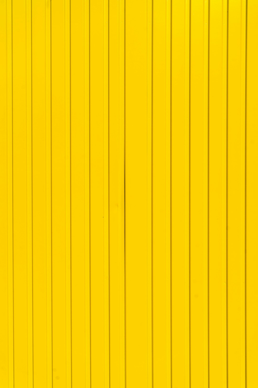 A bright yellow metal wall with vertical lines as background or texture. –ar 85:128