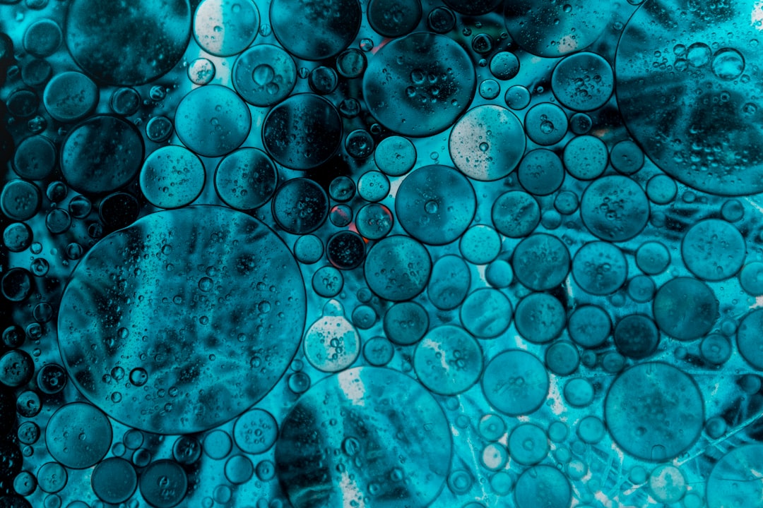 Abstract teal blue bubbles and circles in oil on water, macro photography, high resolution, high detail, closeup, hyper realistic, cinematic –ar 128:85