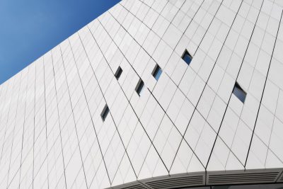 white facade of the museum, white triangular panels with black lines on them, blue sky in background, closeup shot, architectural photography, high resolution --ar 128:85