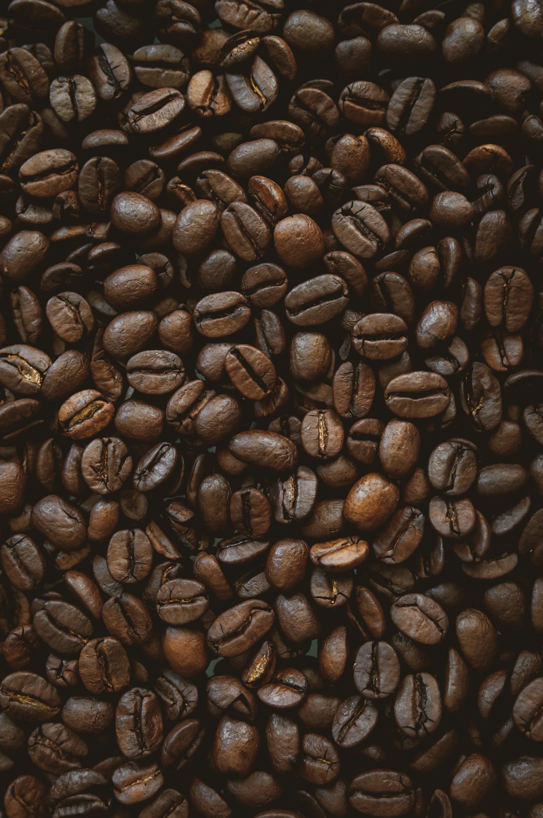 close up of coffee beans, dark background, product photography, studio lighting, high resolution photography, hyper realistic, detailed texture, commercial imagery, professional color grading, cinematic film grain, canon eos r5 –ar 85:128