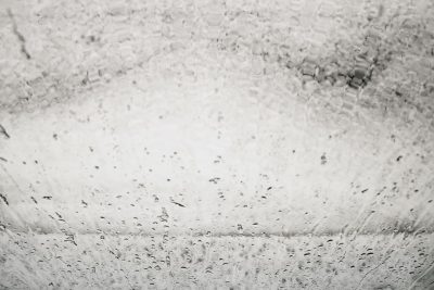 photograph of the interior wall of an old white car wash, water droplets on glass, monochrome --ar 128:85