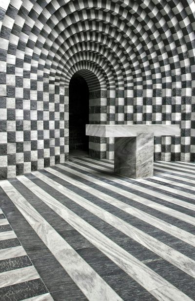 S bolsoni's architectural photography, An optical illusion made of black and white checkered tiles with marble lines leading to an archway in the style of S bolsoni. --ar 83:128