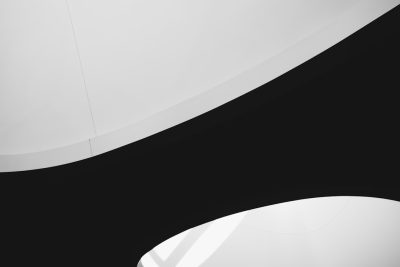 A closeup of the curved ceiling in white, with contrasting black walls, creating an abstract and minimalist background. The focus is on smooth curves that highlight architectural details against a monochromatic backdrop. --ar 128:85