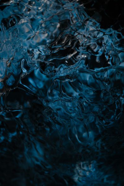 A closeup of dark blue water, capturing the play and texture of ripples in motion, set against a black background. The composition focuses on the intricate details within the fluid environment, creating an atmosphere that evokes calmness and tranquility through visual depth., focus stacking, texture detail, cinematic lighting, low angle shot, wideangle lens, f/4 aperture, ISO 200 for clarity, soft ambient light, no filter, no grainy effect. --ar 85:128