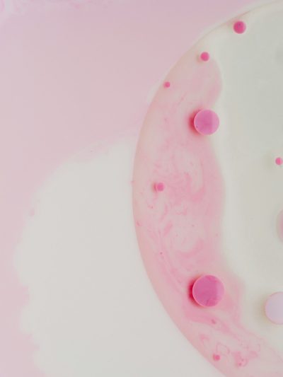 Pink and white pink circles on the surface of milk in an abstract form, creating circular shapes of different sizes, delicate textures, light tones, and a white background. A top view with macro photography using a macro lens under bright lighting to show delicate details with an artistic sense. in the style of --ar 3:4