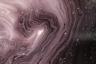 A closeup of swirling, dark liquid with delicate pink and white patterns, resembling the universe's vast expanse, evokes an atmosphere of mystery and magic. The image captures intricate details in the fluidity of colors, creating a mesmerizing visual experience. It is a digital illustration that highlights textures and gradients to highlight depth and contrast between lightness and darkness, evoking a sense of wonder at cosmic beauty. --ar 128:85