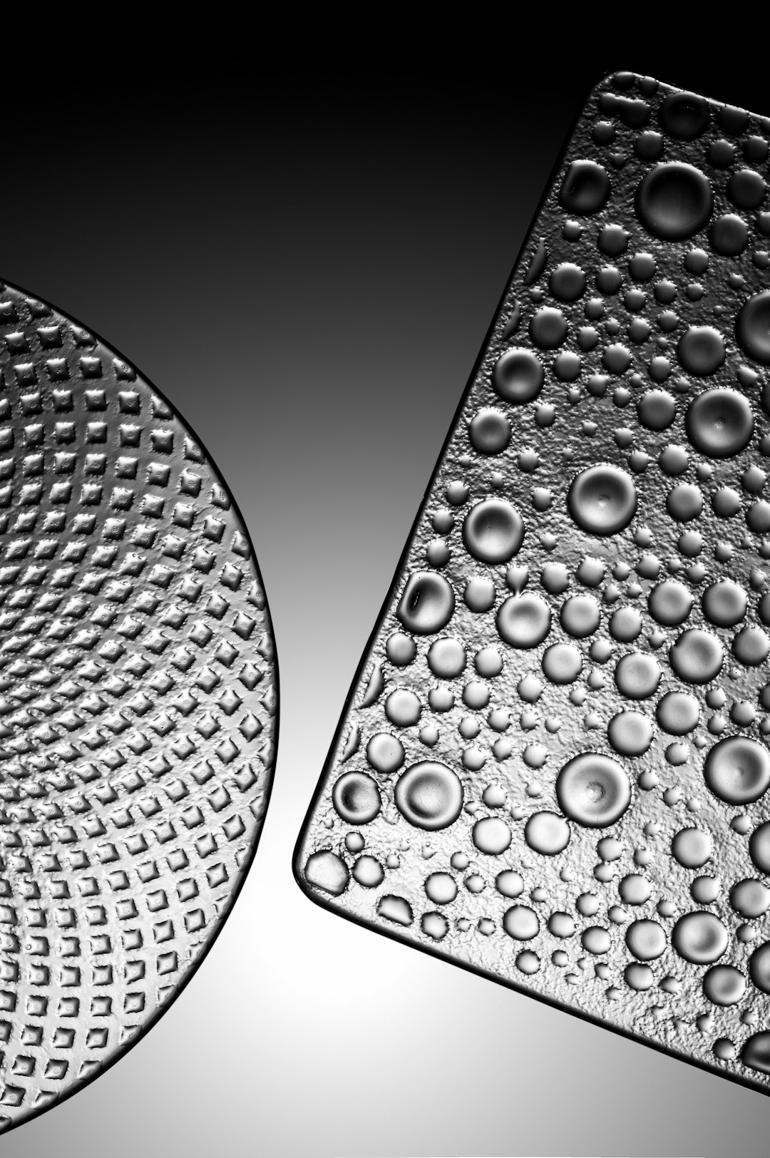 a close up of two different shaped glass textures, one rounded and the other is square with raised round dots on it, the background is black and white, monochromatic, dark gray gradient, texture, high contrast, hyper realistic, photography, studio light, high resolution photography, high definition, high detail, –ar 85:128