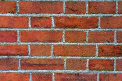 Closeup of a red brick wall texture with gray grout lines in the background. --ar 128:85