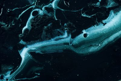 A dark blue and black background with swirling patterns of white paint, resembling the surface of an ocean at night. The color contrast is striking against the deep darkness around it, creating a sense of depth in space. A small amount of light reflections can be seen on some parts of the fluid shapes, adding to its celestial appearance. This image would make for a visually stunning abstract design that captures attention., ultrarealistic photograph captured, highresolution 3D render using Canon EOS5d Mark III camera with lens t0 visible --ar 128:85