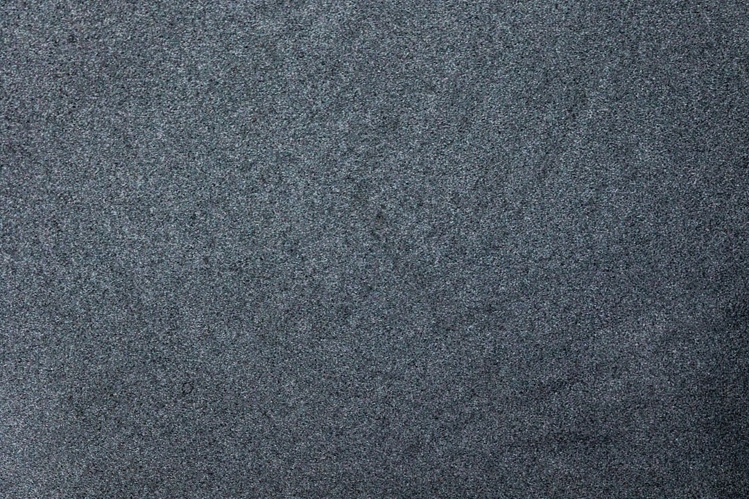 Dark grey carpet texture background, top view. Dark gray soft fabric with small sparkling glitter on the surface –ar 128:85