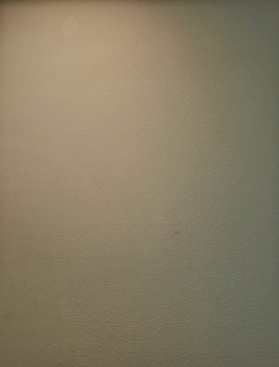 A photo of a plain cream colored wall, close up, taken with an iPhone in the style of a selfie --ar 97:128