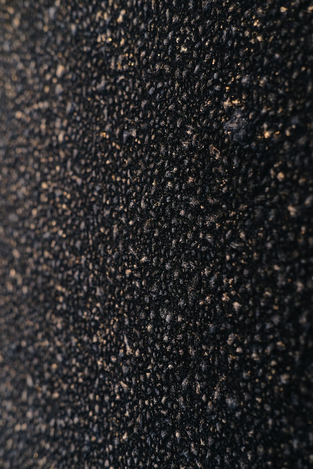 A closeup of asphalt, showing the fine particles and texture that make it perfect for creating textured surfaces in architectural design or interior decoration. With full depth of field in focus, shot on Kodak portra 800 film with added film grain, captured with a Leica, the image is ultra realistic and hyper detailed in the style of documentary photography. –ar 85:128