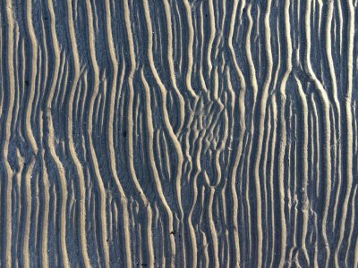 A sand texture with lines of ripples and grooves, resembling wood grain. The dark blue background. --ar 4:3