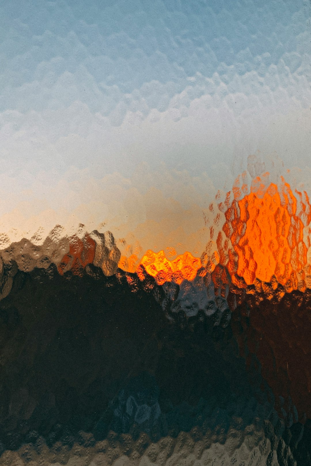 abstract image of sunset over the moutains, blurry, low quality, grainy, orange and blue colors, out focus, photo realistic, textured glass with water droplets on it, blurred foreground –ar 85:128