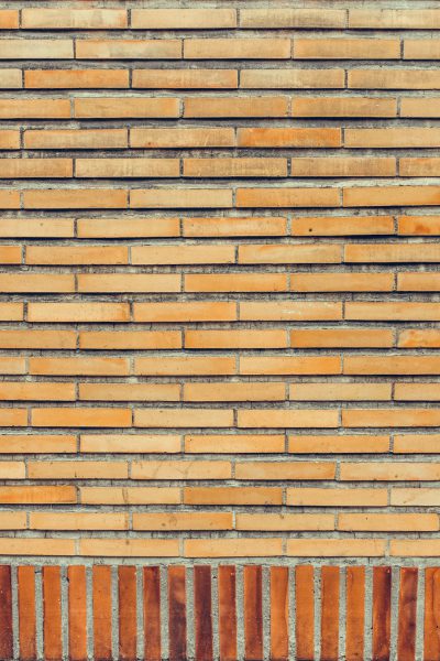 The background of the orange brick wall is made up of horizontal and vertical lines, which create an interesting texture. The wall has different shades of brown bricks that give it a unique appearance. This background would be perfect for various design projects or as a decorative element in interior decoration, in the style of unique brick textures. --ar 85:128