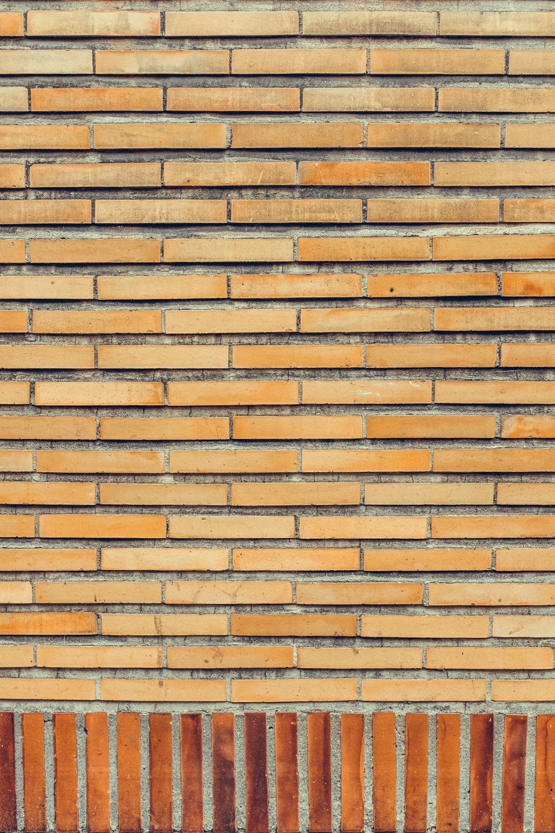 The background of the orange brick wall is made up of horizontal and vertical lines, which create an interesting texture. The wall has different shades of brown bricks that give it a unique appearance. This background would be perfect for various design projects or as a decorative element in interior decoration, in the style of unique brick textures. –ar 85:128