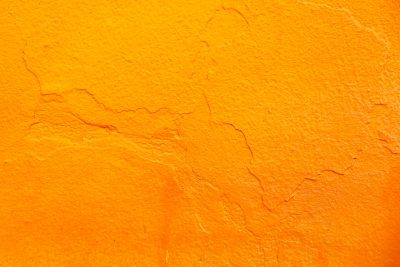 Orange background, rough texture of wall with cracks, closeup. --ar 128:85