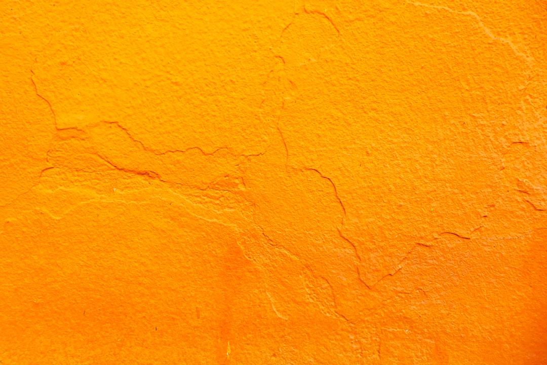 Orange background, rough texture of wall with cracks, closeup. –ar 128:85