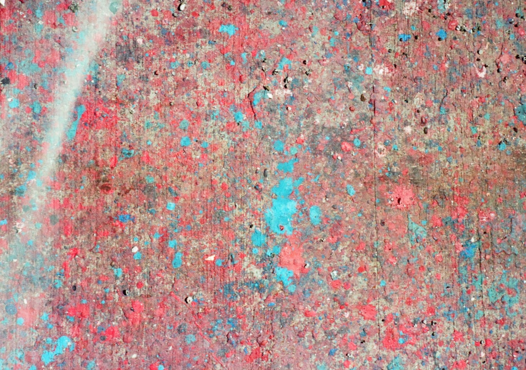 The flat texture of paint splattered on concrete, in red and blue colors. –ar 64:45