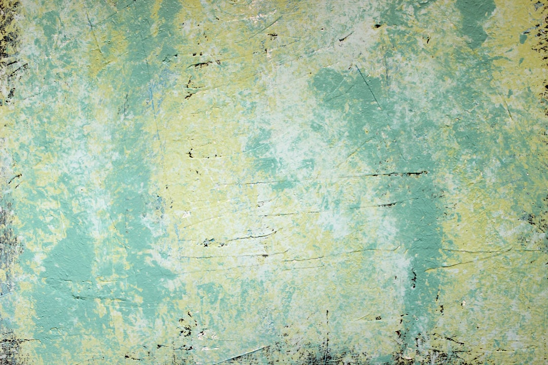 a background of light green and yellow, distressed grunge, painted with a smooth brush texture, with large areas filled in with a soft aquamarine color. The paint has been eroded by time to reveal the natural graininess of its surface. It’s painted on an old wall that is slightly worn at edges due to age and use over many years. There should be some wear marks around the edge where it was bombarded by people who opened up their photos from the past. –ar 128:85