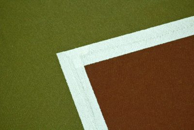 Close up of the white line on an outdoor tennis court, with a brown and green color scheme, in the style of product photography. --ar 128:85