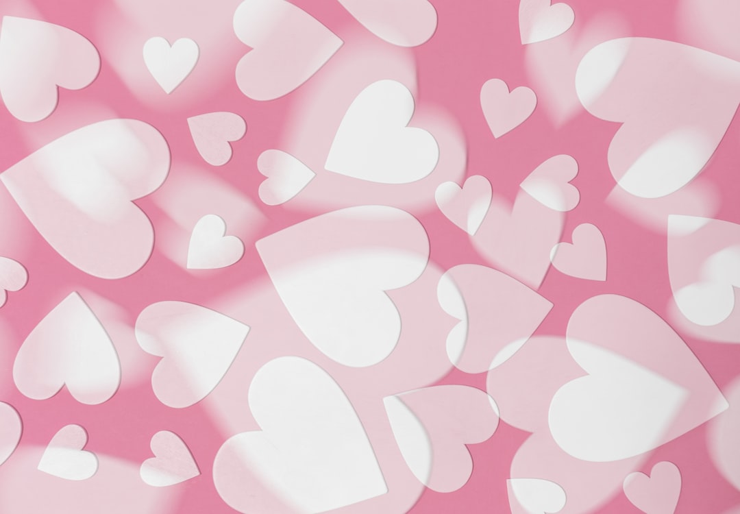 Pink background with white hearts, in the style of pink. –ar 16:11