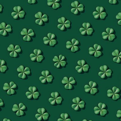 3D shamrock leaves seamless pattern on a dark green background in the style of a st patricks day theme, cute and dreamy digital art style.