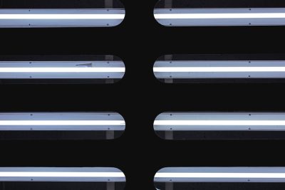 A flat lay of LED tubes on a black background, each panel illuminated with white light and centered in the composition. The lighting creates an illusion that these panels form two horizontal rows, giving depth to the image. --ar 128:85