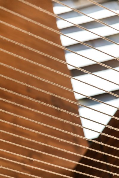 Closeup of blinds with strings, brown and white, against an out-of-focus background. The focus is on the intricate details of the string pattern and texture of each blind's fabric. --ar 85:128