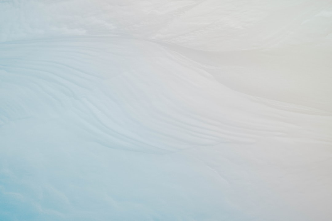 Abstract white and blue background with wavy patterns, closeup of ice on antarctica. Minimalist composition. Soft pastel colors. Low angle shot, macro photography. High resolution. Shallow depth of field. –ar 128:85