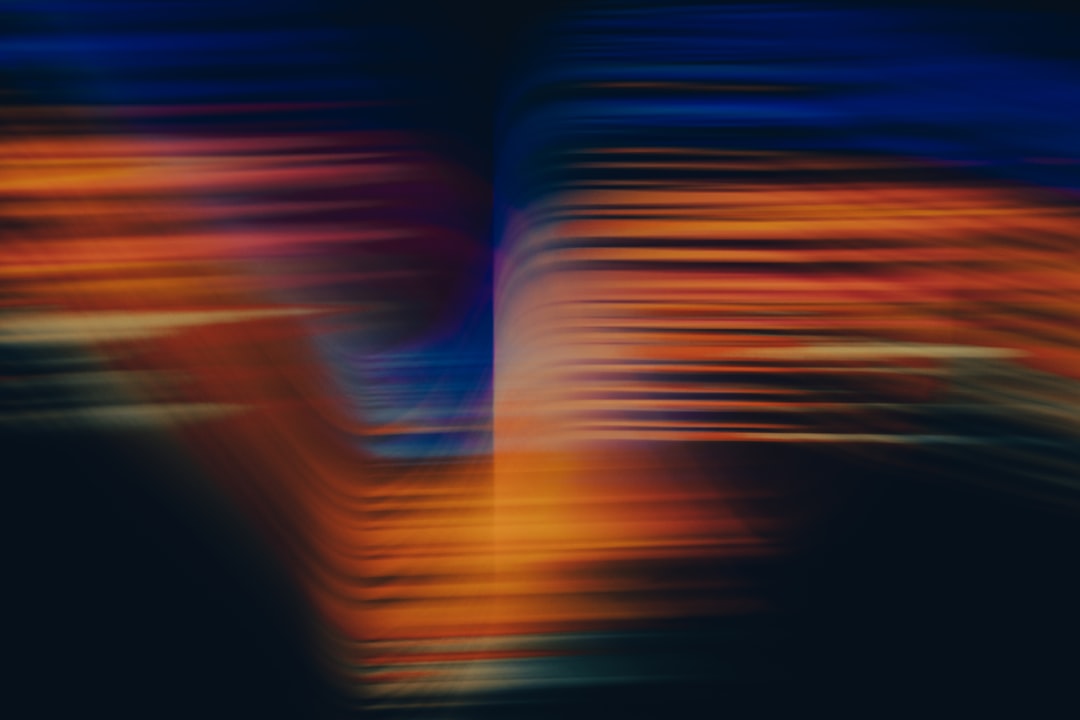 Abstract blurry colorful background with blurred lines of light in the shape of an “V” for design use. In dark blue, orange and yellow colors. Blurred motion of lights. Abstract digital art background. Minimalist design. –ar 128:85