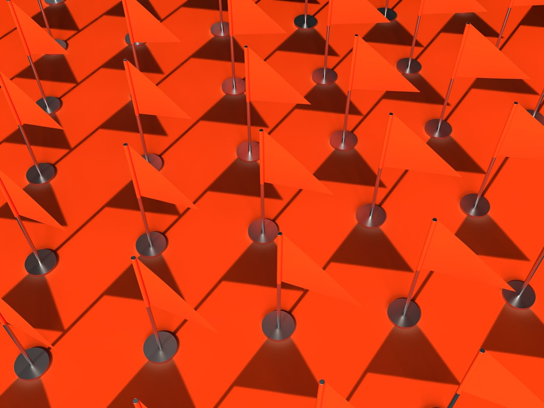 3d render of many orange flags with metal stands arranged in symmetrical geometric shapes on an empty background –ar 4:3