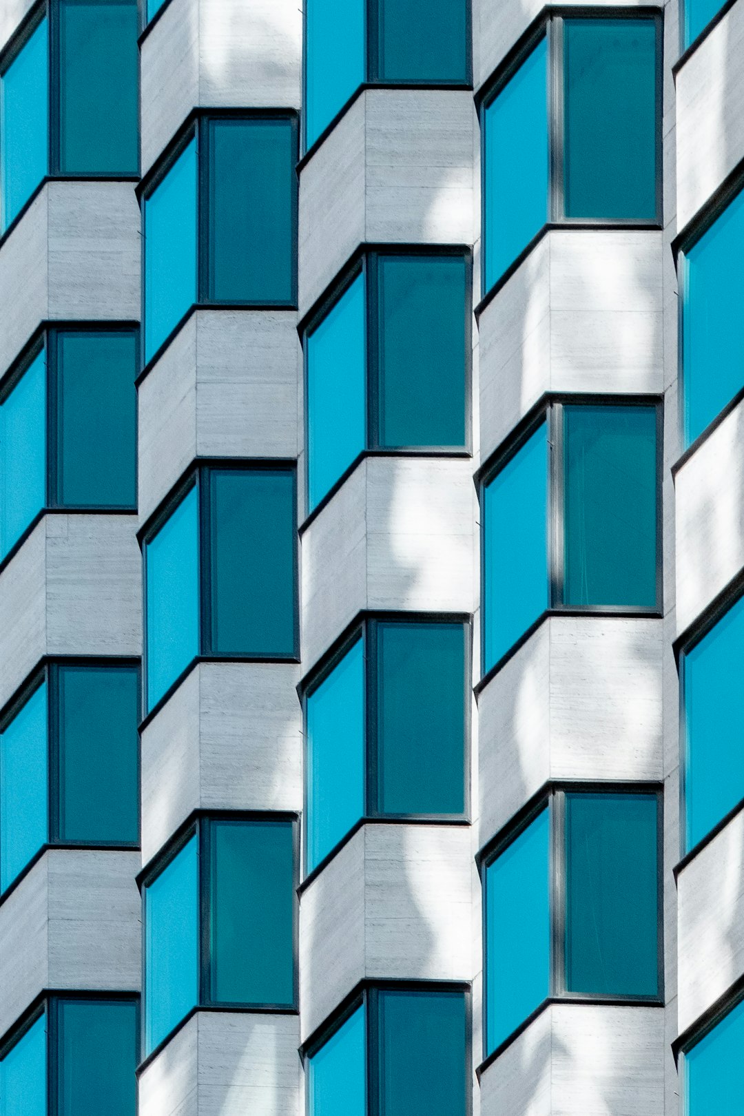 Detail of the facade of a modern building with blue and white patterned windows in the style of archdaily photography. –ar 85:128