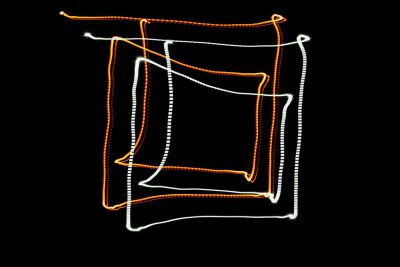 A white and orange glowing line drawing of an abstract rectangular frame on black background, light painting, long exposure photography, aerial view, wide angle lens, redshift render, with loose thin lines that resemble string or fishing wire, creating the outline of shapes around it. The overall effect is one of depth and movement, as if the viewer were peering through layers of translucent fabric. It's a striking contrast between hard edges and soft glow, evoking feelings of wonderment and mystery. --ar 128:85