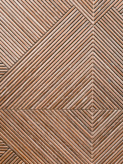 Brown wooden wall with diagonal lines and triangular patterns, texture background. --ar 3:4