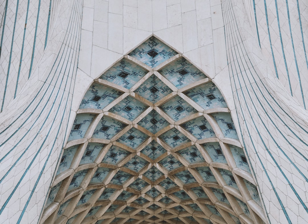 exterior of Azadi tower in Tehran, geometric architecture, symmetrical composition, close up, white and blue color scheme, intricate details, cinematic shot in the style of [Wes Anderson](https://goo.gl/search?artist%20Wes%20Anderson), –ar 128:93