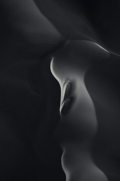 minimalist black and white photography, closeup of female form in the desert, smooth curves --ar 85:128