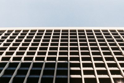 low angle photo of an office building facade, grid pattern on the side, daylight, shot with leica m6 and portra film stock, fujifilm superia --ar 128:85