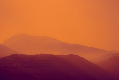 Mountains, orange sky, gradient, photography, realistic, cinematic, golden hour, hazy, warm colors, blurred background, hills of ancient Italy, distant horizon, silhouette, in the style of hills, in the style of hills, in the style of hills --ar 64:43