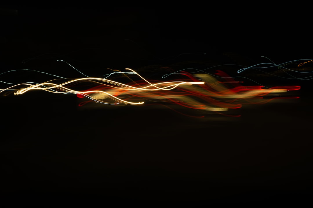 Light painting on black background, light trails, long exposure, red and yellow lines, slow shutter speed photography, soft focus, 2K, high resolution –ar 128:85