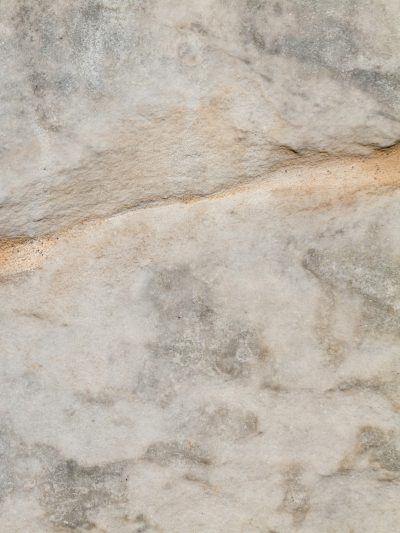 Marble texture, marble background, light gray and white color scheme, flat stone surface, subtle lighting effects, top view angle, high resolution photography, detailed details. High definition images of the edge of rock surfaces with small cracks and crevices, creating an overall sense of realism. The marble has a soft tone, giving it a natural feel. --ar 3:4