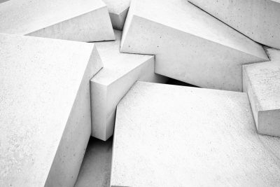 A monochromatic background of overlapping white concrete triangles and squares, creating an abstract composition with a sense of depth and perspective. The shapes form dynamic patterns that suggest movement or structure within the backdrop. The patterns are in the style of overlapping white concrete triangles and squares, creating an abstract composition with a sense of depth and perspective. The shapes form dynamic patterns that suggest movement or structure within the backdrop. --ar 128:85