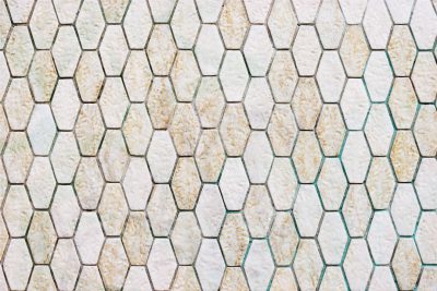 A hexagonal tile pattern of white and green tiles with a light brown color on the surface, in a top view, flat layout. The background features an elegant wall made from beige stone or marble. High resolution, professional photograph, sharp focus, studio lighting, crisp details in the style of HDR. --ar 128:85