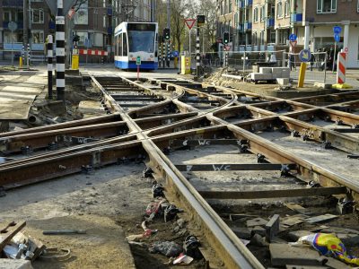 Dutch tram tracks broken and all over the place in amsterdam, with construction materials scattered around it, --ar 4:3