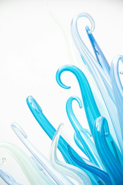 Closeup of glass sculptures, light blue and white, abstract shapes, delicate curves, swirls, white background, high resolution --ar 85:128