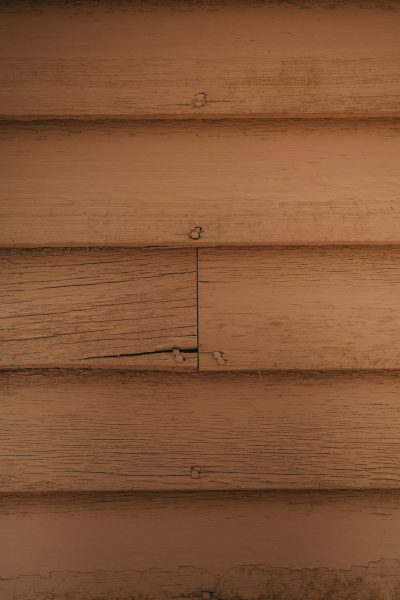 Photorealistic close-up of the wood texture on an old cabin wall, warm tones, low angle view, simple, minimalist, symmetrical. --ar 85:128